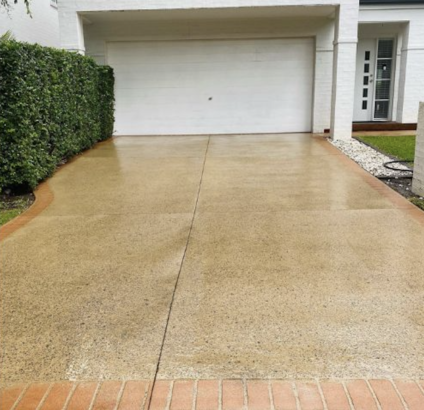 After: Dirty driveway with brick border before and after power washing