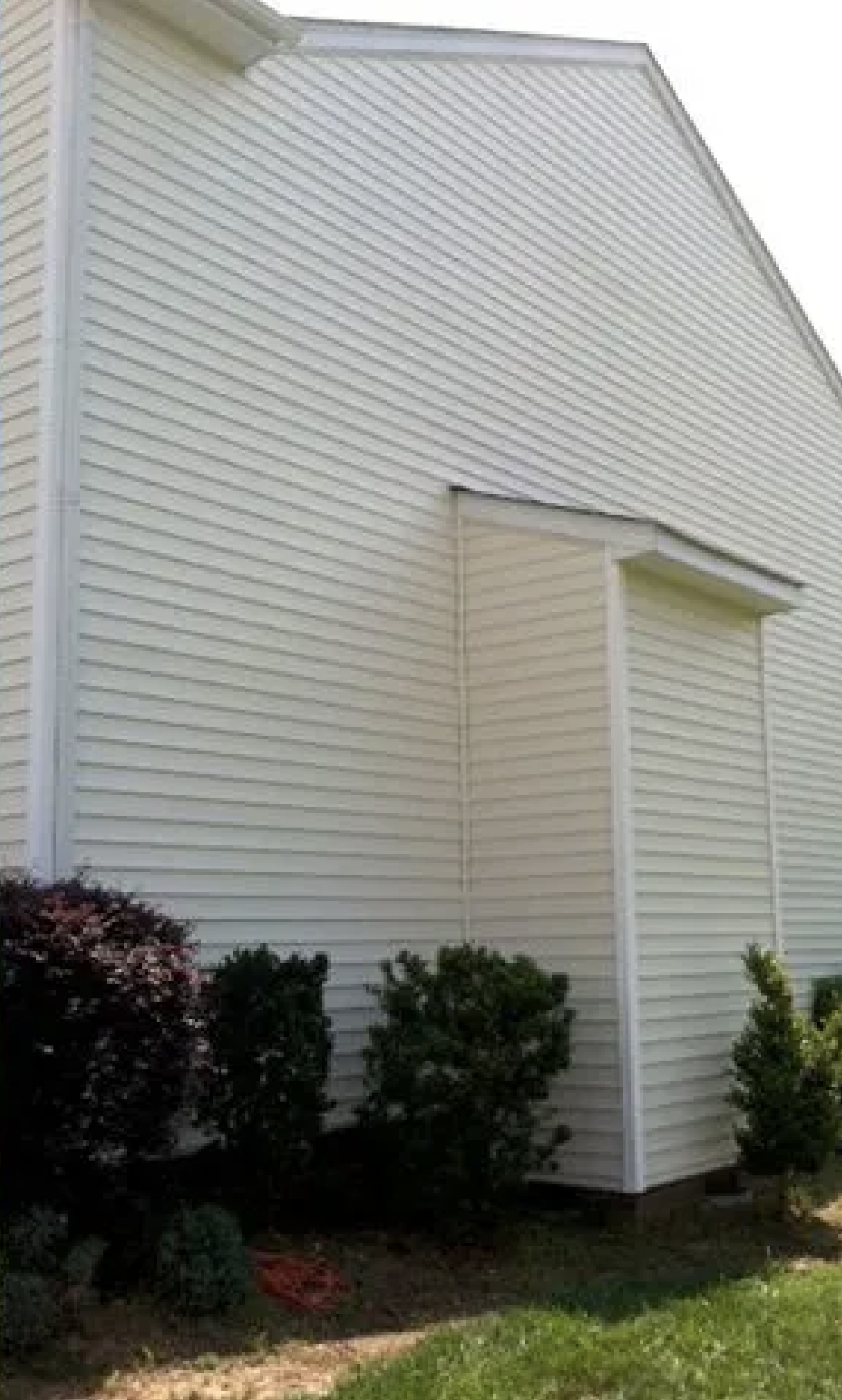 After: House exterior with bushes before and after cleaning